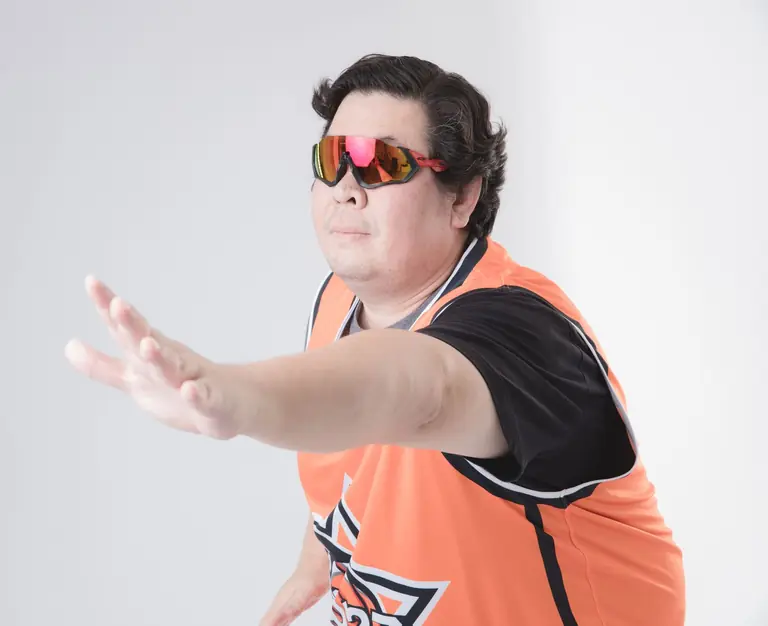 Adult man in sportswear posing with VR glasses in a studio setting on a white background.