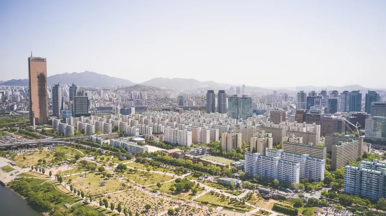 Aerial view showcasing the vibrant cityscape of Seoul with iconic skyscrapers and lush green parks.