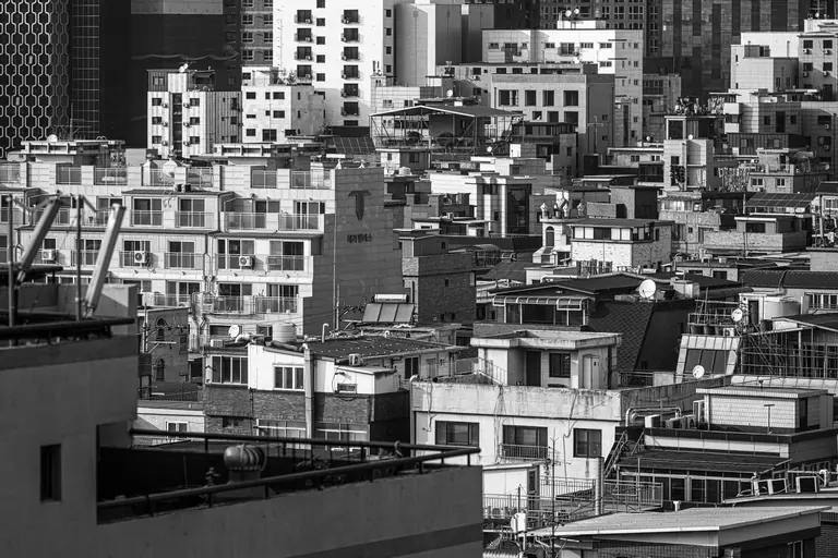 Black and white cityscape of Seoul with diverse architectural styles.