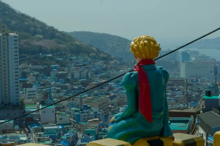 a statue of a man sitting on top of a building