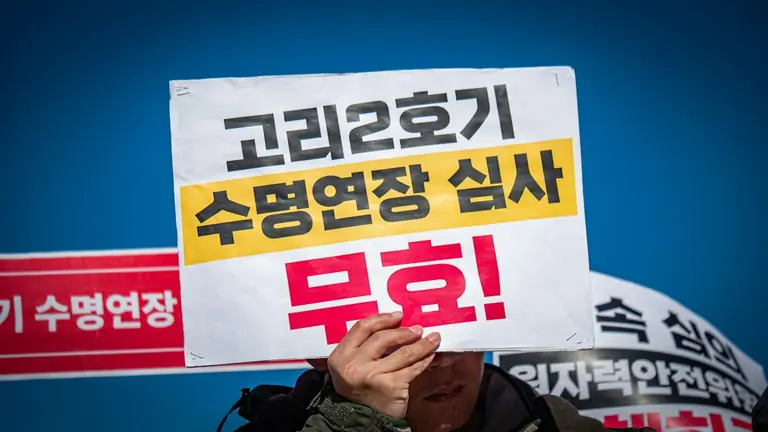Person holds sign protesting nuclear power plant operation