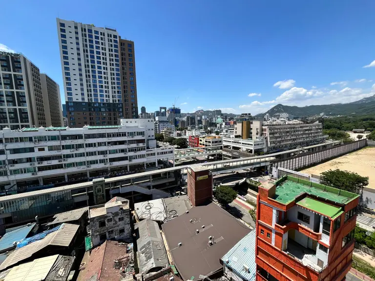 Aerial view of a bustling cityscape with skyscrapers under a clear blue sky.
