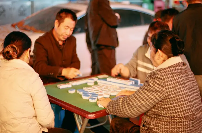 People are playing a game of mahjong together